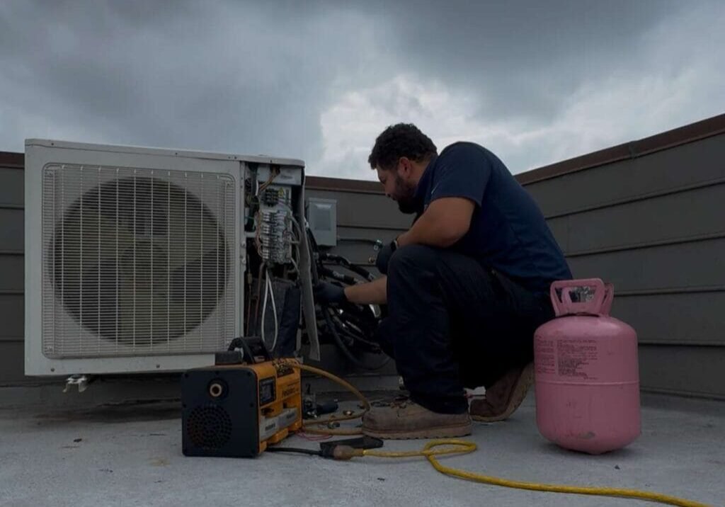 HVAC Technician Performing Maintenance on Rooftop Unit HVAC Technician Performing Maintenance on Rooftop Unit