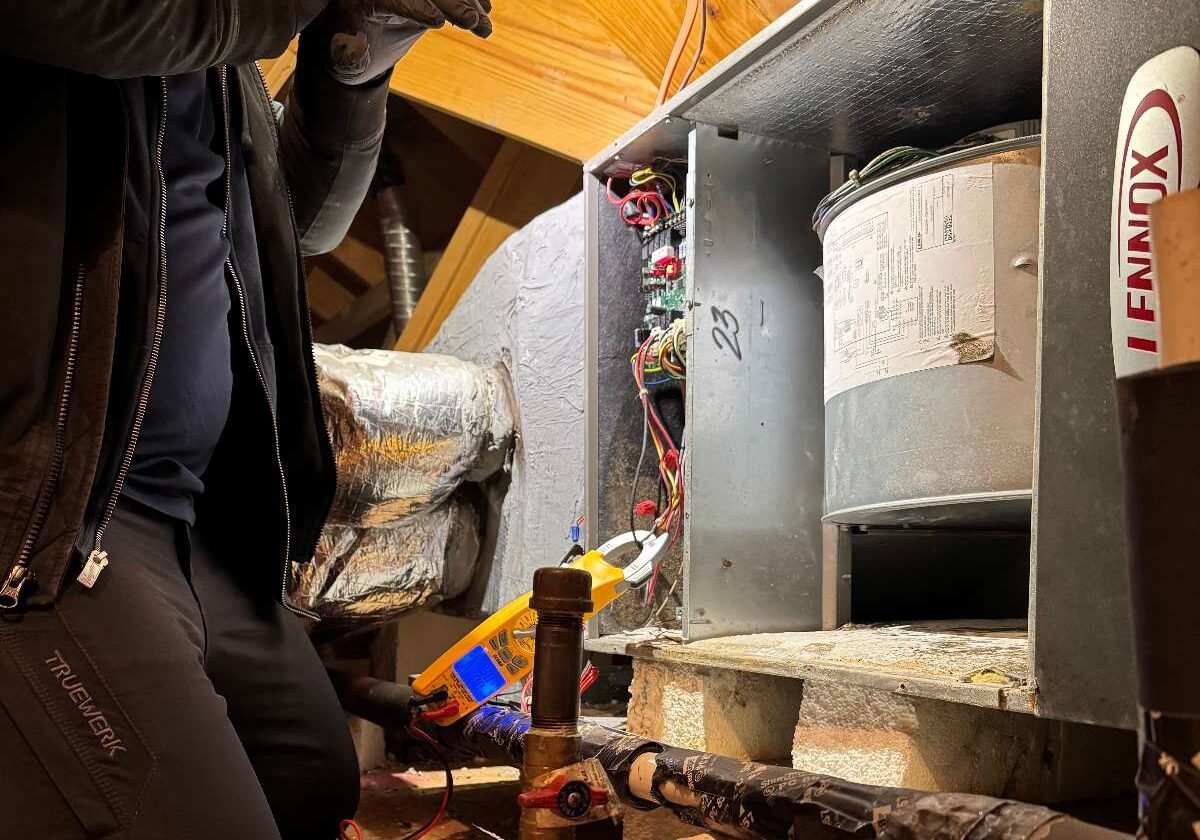 HVAC Technician Troubleshooting in Attic HVAC Technician Troubleshooting in Attic